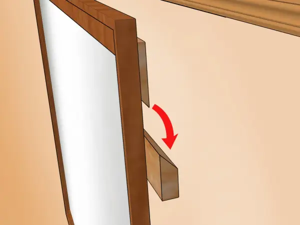 Detalle de cómo colgar un espejo. Se muestra un soporte de madera que se desliza hacia abajo para asegurar el espejo.