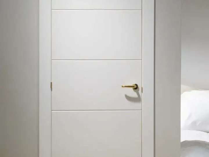 Puerta lacada en blanco con tirador dorado. Aprende como limpiar puertas lacadas en blanco para mantenerlas impecables.